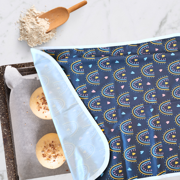 Reusable, eco-friendly non-stick cookie sheet pan proofing cover in rainbow print for keeping dough moist while proofing.