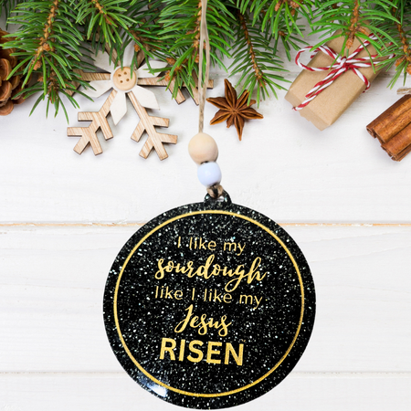 I Like My Sourdough Like I Like My Jesus: RISEN' Christmas ornament on black glittery acrylic, hand-painted in gold